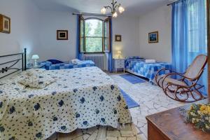 een slaapkamer met twee bedden en een stoel erin bij La Loggetta - Apartments in Gaiole in Chianti +39 foto's
