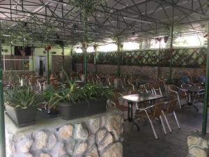 a restaurant with tables and chairs and plants in a room at Paradox Movila in Eforie Sud
