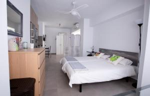 Un dormitorio blanco con una cama y una cocina. en Apartamento Malagueta Beach 10, en Málaga 16 fotos más