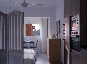 Un dormitorio con una cama y una cocina con una mesa. en Apartamento Malagueta Beach 10, en Málaga