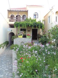 a garden in front of a house with flowers at Smaragda Hotel in Marathokampos