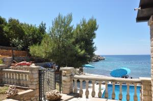 a beach with a fence and a blue umbrella at Holidayhome Florecka in Utjeha
