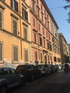 una fila di auto parcheggiate davanti a un edificio di Fanti Rooms a Roma