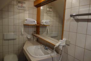 a bathroom with a sink and a mirror and towels at Goldenes Schiff Hotel-Mietparkplätze in Engelhartszell