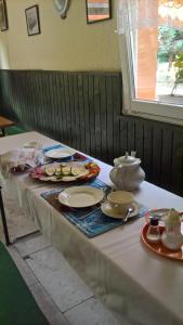 a table with plates and dishes on top of it at Cseppkő Panzió in Abaliget