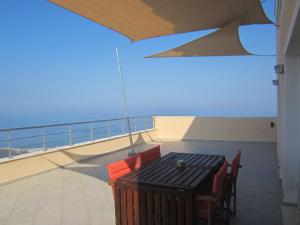 a balcony with a table and chairs on a ship at Viva B&B in Anavyssos
