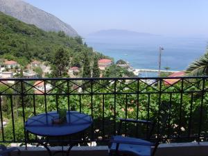 een balkon met een tafel en uitzicht op de oceaan bij Giannatos' Studios - Makis in Póros