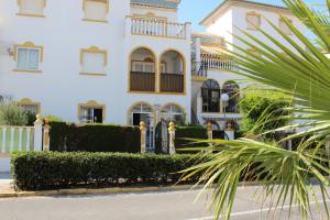 biały dom z palmą przed nim w obiekcie Geraneos Playa w mieście Torrevieja