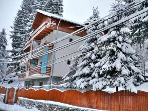 ein Haus im Schnee mit einem Zaun in der Unterkunft Pension Casa Soarelui in Sinaia