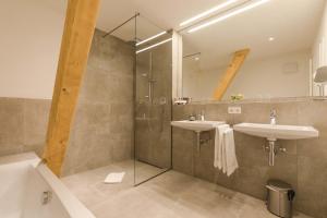 a bathroom with two sinks and a shower at GADEN Apartment - Hotel in Waging am See +77 photos