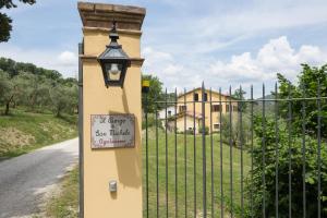 un pôle lumineux avec un panneau à côté d'une clôture dans l'établissement Il Borgo Di San Michele, à Papigno