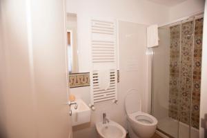 a white bathroom with a toilet and a sink at B&B Nencioli in Castellammare del Golfo +36 photos