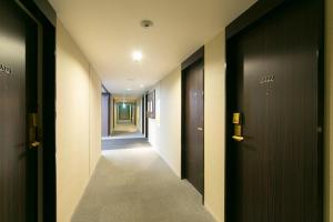 a hallway with black doors and a hallway with a hallwayngth at Shin Osaka Washington Hotel Plaza in Osaka