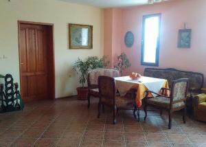 a dining room with a table and chairs and a window at Fenix Rooms in Arbanasi