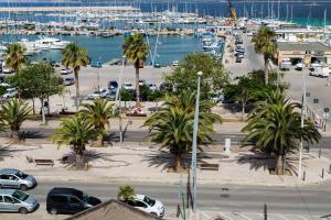 een parkeerplaats met palmbomen en een jachthaven bij Butterfly Accommodation in Alghero