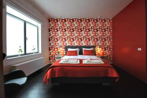 um quarto vermelho com uma cama e uma parede vermelha em B&B Kava em Antuérpia