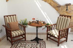 two chairs and a table in a room at Pedieos Guest House in Lefkosa Turk