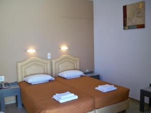 ein Schlafzimmer mit einem Bett mit zwei Handtüchern darauf in der Unterkunft Palladion in Adelianos Kampos