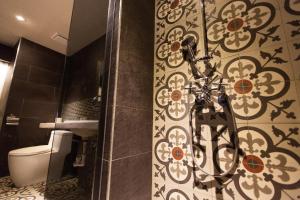 łazienka z toaletą i ścianą wyłożoną kafelkami w obiekcie Chihpen Hotel Royal Kingdom w mieście Wenquan