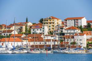 een groep boten aangemeerd in een haven met gebouwen bij Rooms Carija in Trogir