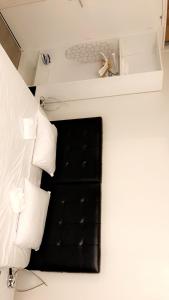 パリにあるSuite Cocoon Parisの黒い椅子と白い枕が備わる客室です。