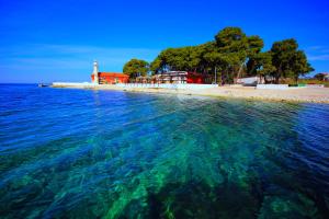 a body of water with a lighthouse and a beach at Puntamika studio in Zadar