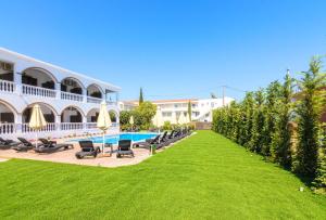 拉加纳斯Alterego Studios的一个带椅子的大院子和一个游泳池的度假胜地