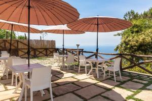 a group of tables and chairs with umbrellas at Villa Prestige in Sorrento