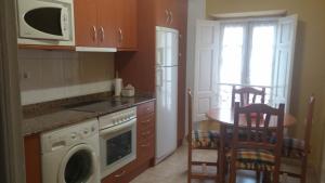 Una pequeña cocina con una mesa y un microondas. en Apartamentos Puente Viesgo Viviendas Rurales, en Puente Viesgo