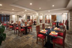 uma sala de jantar com mesas e cadeiras de madeira em Golden Villa Sapa Hotel em Sa Pa