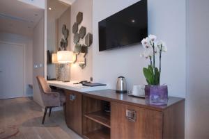 a home office with a desk with a vase of flowers at Hotel Riva by Aycon in Petrovac na Moru