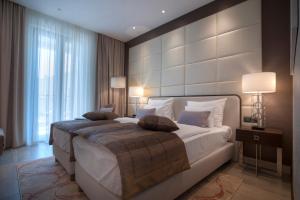 a bedroom with a large white bed with two pillows at Hotel Riva by Aycon in Petrovac na Moru