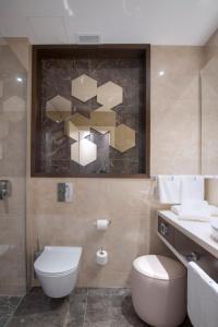 a bathroom with a toilet, sink, and bathtub at Hotel Riva by Aycon in Petrovac na Moru