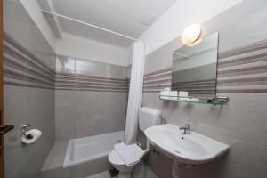 a bathroom with a sink, toilet and bathtub at Apartments Kovačić in Makarska