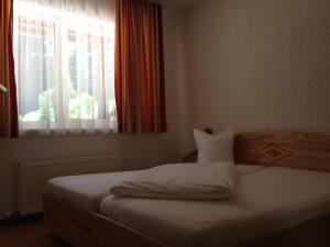パーテネンにあるHotel Zerresの窓と白いベッドサイドシックスが備わるドミトリールームのベッド1台分です。