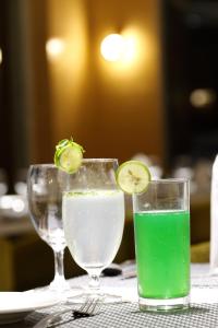two glasses of water and a lime on a table at Hotel Silver Heights in Ahmedabad