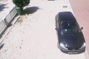 a black car parked in a parking lot at Holiday Home Turalija in Vodice