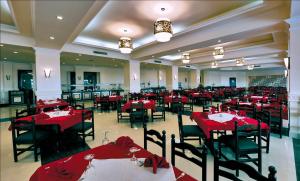 une salle à manger avec des tables et des chaises rouges dans l'établissement Aida Beach Hotel - El Alamein, à El Alamein