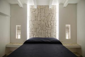 a bed in a room with a stone wall at Malia Village in Vieste