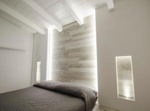 a bedroom with a bed and a stone wall at Malia Village in Vieste