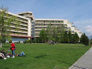 um grupo de pessoas sentadas na relva em frente a um edifício em Luxury Apartment Eurotel em Struga