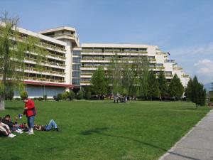 a group of people sitting on the grass in front of a building at Luxury Apartment Eurotel in Struga