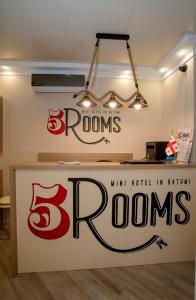 a sign for a room with browns andrams on the wall at 5 Rooms in Batumi