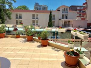 eine Terrasse mit Topfpflanzen und ein Swimmingpool in der Unterkunft Maverick Hotel in Sonnenstrand