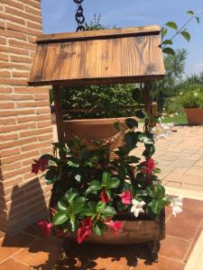 a wooden planter with flowers on a patio at Casale Del Borgo in Hermada