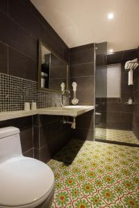 La salle de bains est pourvue de toilettes, d'un lavabo et d'une douche. dans l'établissement Chihpen Hotel Royal Kingdom, à Wenquan