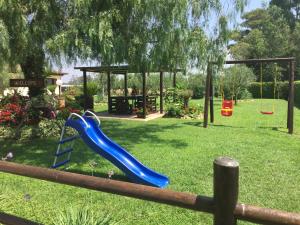 a playground with a blue slide in a yard at Casale Del Borgo in Hermada