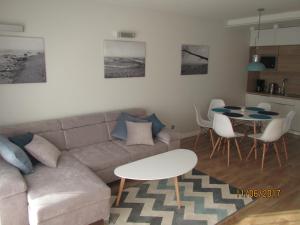 a living room with a couch and a table at Apartament z ogrodkiem in Pogorzelica