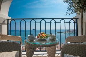 a table with a bowl of fruit on a balcony at Hotel Riva by Aycon in Petrovac na Moru
