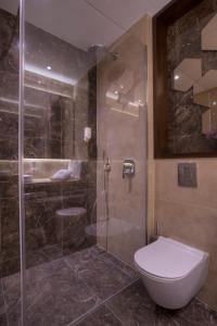 a bathroom with a shower and a toilet and a sink at Hotel Riva by Aycon in Petrovac na Moru